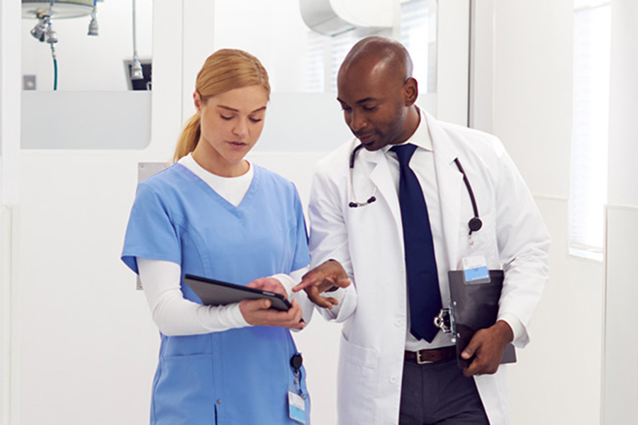 A nurse discussing a patient file with a physician